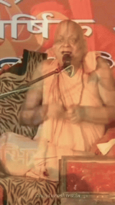A Man Is Speaking Into A Microphone And The Website Behind Him Says ' Ohindurashtra.in ' GIF