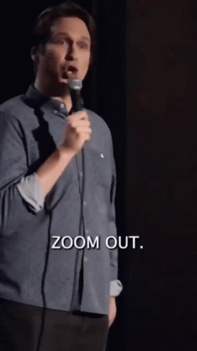 A Man Is Speaking Into A Microphone And The Words Zoom Out Are Above Him GIF