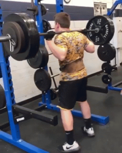 A Man Is Squatting With A Barbell That Says Barbell On It GIF