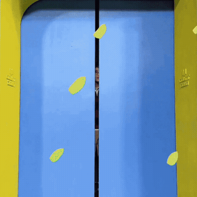A Man Is Standing In A Blue And Yellow Doorway With A Heart On It GIF