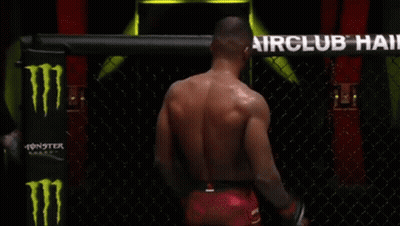 A Man Is Standing In A Boxing Ring In Front Of An Airclub Hair Sign GIF