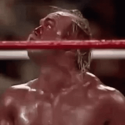 A Man Is Standing In A Boxing Ring With Blood Coming Out Of His Eyes . GIF