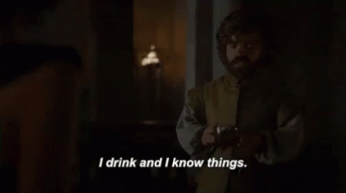 A Man Is Standing In A Dark Room Holding A Glass Of Wine And Saying `` I Drink And I Know Things '' . GIF
