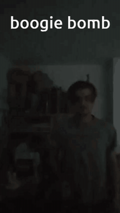 A Man Is Standing In A Dark Room With The Words Boogie Bomb Written Above Him GIF