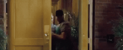 A Man Is Standing In A Doorway Holding A Woman 'S Hand . GIF