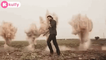 A Man Is Standing In A Field With Smoke Coming Out Of It . GIF