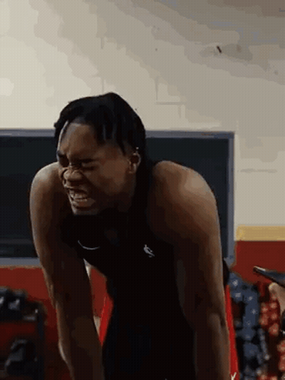 A Man Is Standing In A Gym With His Arms Outstretched And His Mouth Open . GIF
