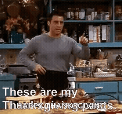 A Man Is Standing In A Kitchen With His Hands On His Hips And Pointing . GIF