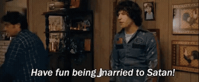 A Man Is Standing In A Living Room Talking To Another Man And Saying `` Have Fun Being Married To Satan '' . GIF