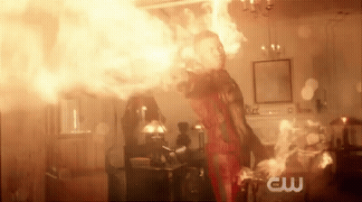 A Man Is Standing In A Room With A Lot Of Fire Coming Out Of His Hands . GIF