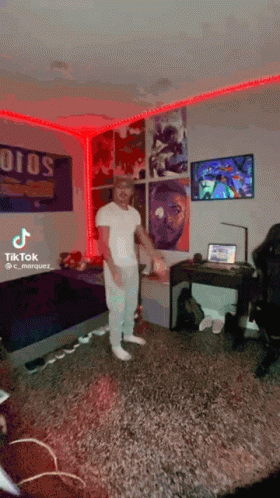 A Man Is Standing In A Room With A Sign That Says ' Ojos ' On It GIF