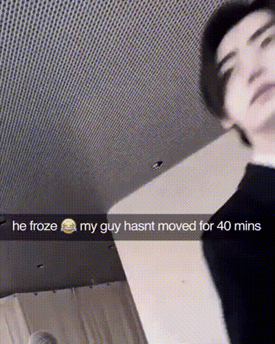 A Man Is Standing In A Room With A Snapchat Caption That Says He Froze My Guy Hasnt Moved For 40 Mins GIF