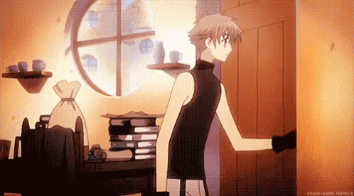 A Man Is Standing In A Room With A Stack Of Books On A Table And A Window . GIF