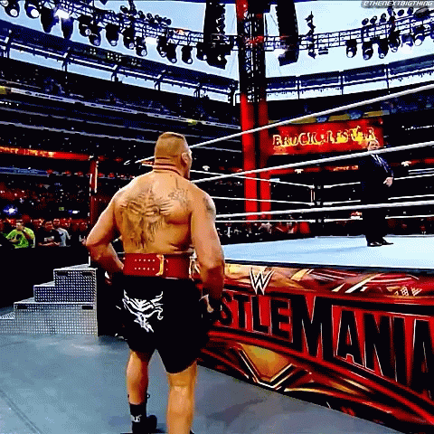 A Man Is Standing In A Wrestling Ring In Front Of A Sign That Says ' Wrestling ' On It GIF