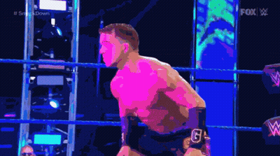 A Man Is Standing In A Wrestling Ring With A Fox Logo Behind Him GIF