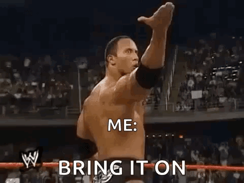 A Man Is Standing In A Wrestling Ring With His Fist In The Air . GIF