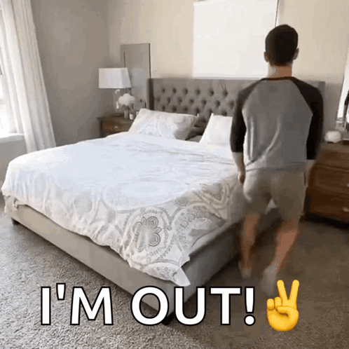 A Man Is Standing In Front Of A Bed With The Words I 'M Out GIF