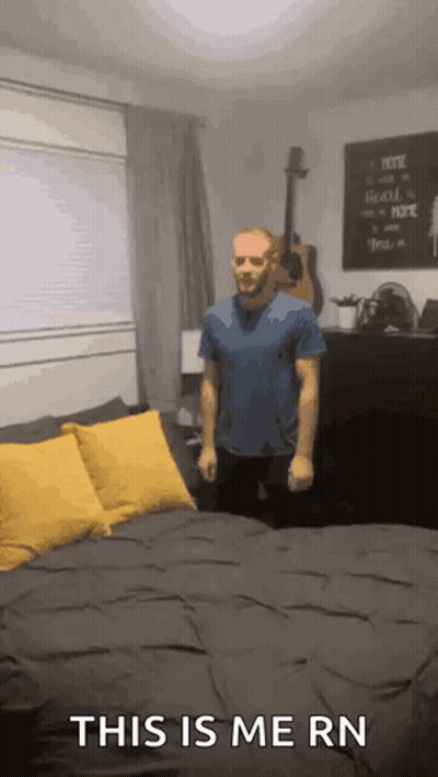 a man is standing in front of a bed with the words this is me rn on the bottom