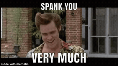 A Man Is Standing In Front Of A Brick Building With The Words `` Spank You Very Much '' Written On It . GIF