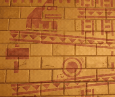 A Man Is Standing In Front Of A Brick Wall With A Drawing Of A Bird On It GIF