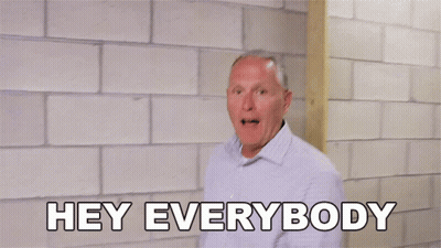 A Man Is Standing In Front Of A Brick Wall With His Arms Outstretched And Says Hey Everybody GIF
