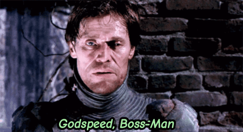 A Man Is Standing In Front Of A Brick Wall With The Words Godspeed Boss-Man Above Him GIF