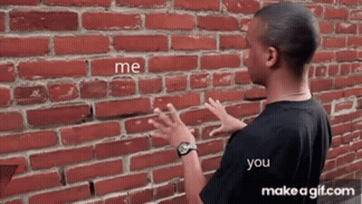 A Man Is Standing In Front Of A Brick Wall With The Words Me And You Written On It GIF