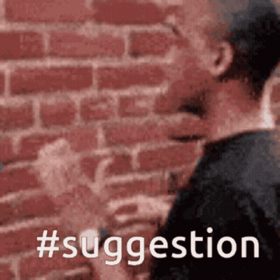 A Man Is Standing In Front Of A Brick Wall With The Words #Suggestion Written On It GIF