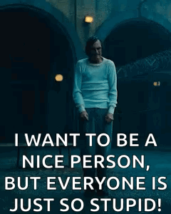 A Man Is Standing In Front Of A Building And Smoking A Cigarette . GIF