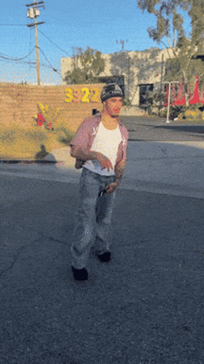 A Man Is Standing In Front Of A Building That Has The Number 3922 On It GIF