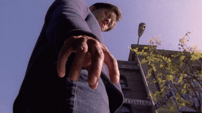 A Man Is Standing In Front Of A Building That Says Fayette On It GIF