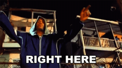 A Man Is Standing In Front Of A Building With His Arms Outstretched . GIF