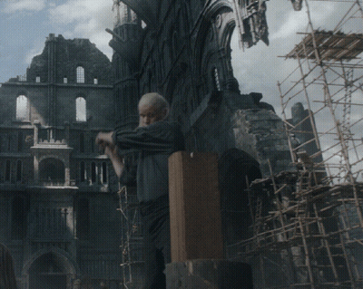 A Man Is Standing In Front Of A Building With Scaffolding In Front Of It GIF