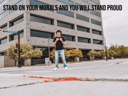 A Man Is Standing In Front Of A Building With The Words Stand On Your Morals And You Will Stand Proud GIF