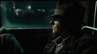 A Man Is Standing In Front Of A Cafe At Night GIF