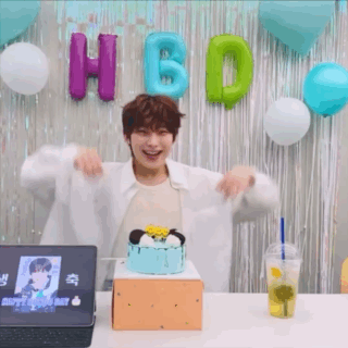 A Man Is Standing In Front Of A Cake And Balloons . GIF