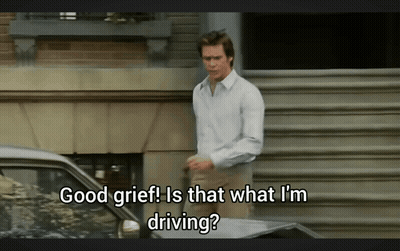 A Man Is Standing In Front Of A Car With The Words Good Grief Is That What I 'M Driving GIF