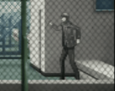 A Man Is Standing In Front Of A Chain Link Fence In A Room . GIF
