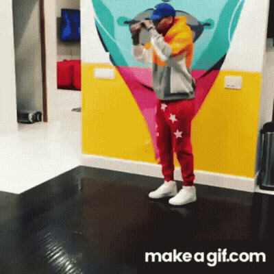 A Man Is Standing In Front Of A Colorful Wall With A Make A Gif.com Logo GIF