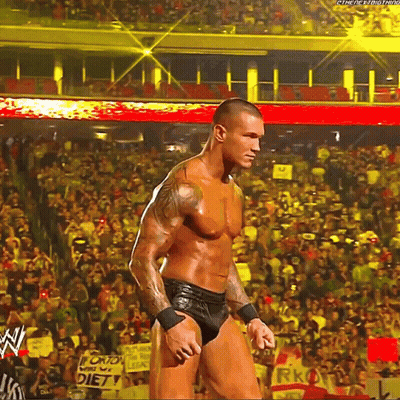 A Man Is Standing In Front Of A Crowd In A Stadium With A Sign That Says Diet On It . GIF