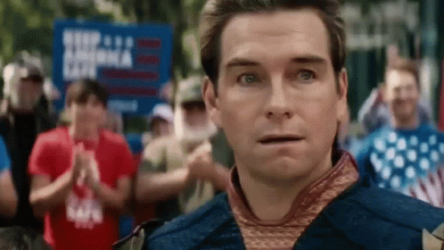 A Man Is Standing In Front Of A Crowd Of People And Looking At The Camera With A Surprised Look On His Face . GIF