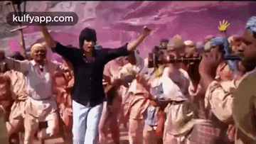 A Man Is Standing In Front Of A Crowd Of People Dancing . GIF
