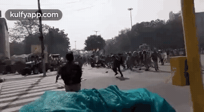 A Man Is Standing In Front Of A Crowd Of People On A City Street . GIF