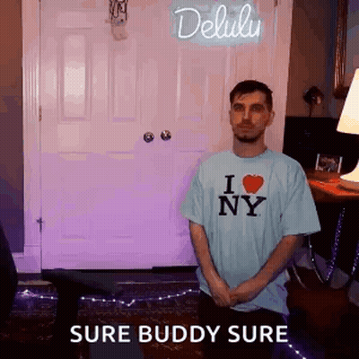 A Man Is Standing In Front Of A Door Wearing A I Love Ny Shirt . GIF