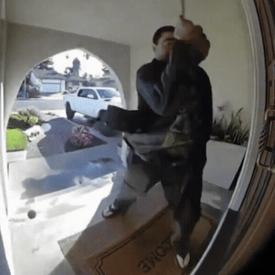 A Man Is Standing In Front Of A Door With A Welcome Mat On It GIF