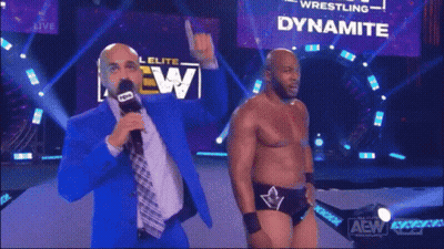 A Man Is Standing In Front Of A Dynamite Sign GIF