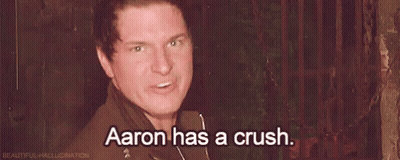 A Man Is Standing In Front Of A Fence And Saying `` Aaron Has A Crush '' . GIF