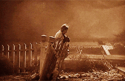 A Man Is Standing In Front Of A Fence In A Sepia Toned Photo GIF