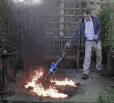 A Man Is Standing In Front Of A Fire Pit GIF