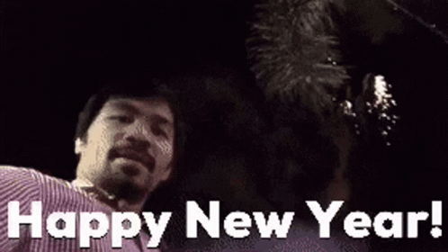 A Man Is Standing In Front Of A Fireworks Display And Says Happy New Year ! GIF